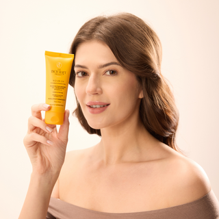 Model holding FaceCraft Nourish spf 50+ Broad spectrum sunscreen dermatologist crafted for UV protection and hydration